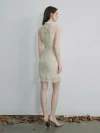Back view of a woman in a white modern Chinese cheongsam dress, standing outdoors to show the full lace pattern on the back, the fitted silhouette, and the ruffled hem.
