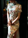Close-up of the upper body of a Chinese silk white floral print qipao dress, showing the traditional mandarin collar, frog buttons, and delicate floral pattern details.