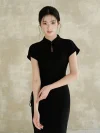 Bust shot of a woman wearing a black slim fit qipao dress. The women qipao features a classic stand collar with a keyhole opening, emphasizing a sleek and elegant silhouette.