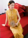 Modern Chinese Yellow Cheongsam Wedding Dress - Bride sitting on red wedding bed holding traditional fan, two-piece brocade cheongsam with floral jacquard and pearl tassel details