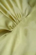 Close-up shot of the side ruching on a women's modern chinese mulberry silk cheongsam shirt, highlighting the smooth, lustrous texture of the premium mulberry silk fabric featured in this water drop collar short sleeve qipao top.