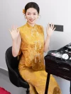 Modern Chinese Yellow Cheongsam Wedding Dress - Bride in two-piece sleeveless brocade cheongsam waving cheerfully during bridal prep, showcasing pearl tassel frog buttons and floral jacquard fabric, elegant traditional qipao for wedding ceremonies