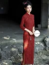 A refined lady modeled in a classic long sleeve qipao dress with elegant side slits, holding a delicate fan and standing gracefully on a stone-embedded pathway.
