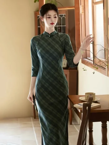 Charming woman in a green long sleeve cheongsam dress, gently touching a plant branch next to a wooden window, with a cozy morning coffee setting on the side table.