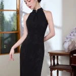 Graceful look of a woman in a modern black halter cheongsam with subtle floral textures, looking down with her hair styled in a classic bun.