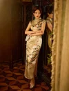 Stylish woman wearing a cheongsam formal yellow silk dress with a high side slit, standing elegantly in front of a full-length mirror holding a clutch.